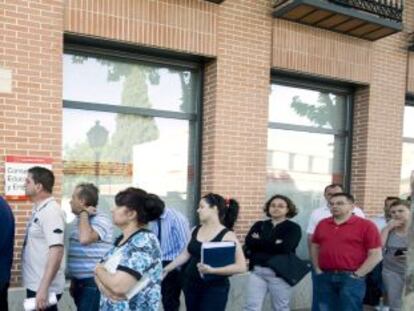 Un grupo de personas hace cola en una oficina de empleo en Alcalá de Henares.