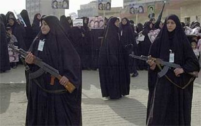 Varias mujeres vigilan una procesión de fieles chiíes celebrada ayer en una de las principales mezquitas de Bagdad.