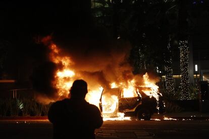 Las protestas contra el racismo se multiplicaron por el resto del país, desde la Casa Blanca, en Washington, a Atlanta, pasando por Nueva York, Dallas o Los Ángeles, en algunos casos, con graves altercados. En la imagen, un hombre graba un vehículo policial en llamas durante una protesta en Los Ángeles.