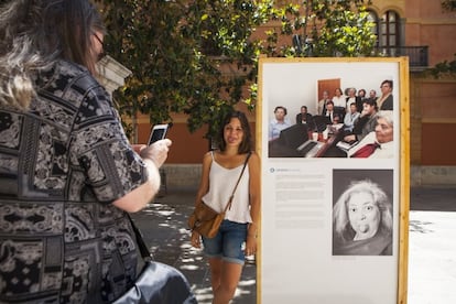 A passerby poses with the Lideresas recreation of the photo of Barack Obama and his Cabinet members.