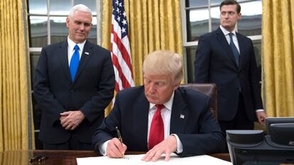 El presidente Donald Trump el 20 de enero de 2017, su primer día en el Despacho Oval, firma la confirmación del nombramiento del secretario de Defensa, James Mattis, ante su vicepresidente Mike Pence (izquierda).