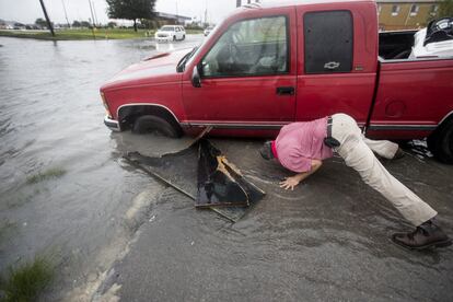 Un hombre trabaja para sacar su camión de una zanja llena de agua durante la tormenta tropical Imelda en Houston.