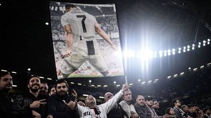 Aficionados de la Juventus sostienen un póster de Cristiano Ronaldo. 