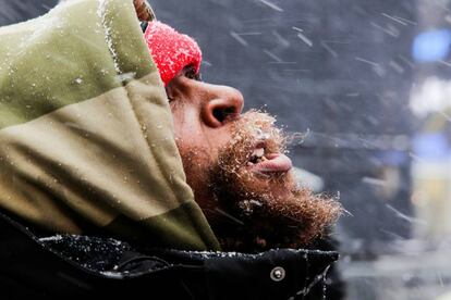 Un hombre observa la nieve que cae sobre Nueva York.
