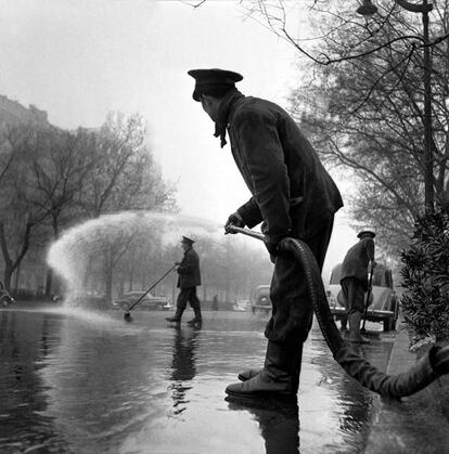 Un operario riega el madrileño paseo Recoletos en una fotografía de Francesc Català-Roca de 1953.