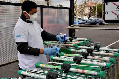 Un trabajador desinfecta los carros de la compra de Mercadona, este martes.