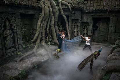 Los novios posan para una fotografía preboda en el estudio 27 Rome Brand de Pekín, que luce como el interior del monumento camboyano Angkor Wat, el 20 de septiembre de 2018.