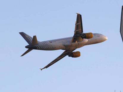 Un avión A320-200 de Vueling sobrevuela la torre de control del aeropuerto de Barcelona-El Prat.