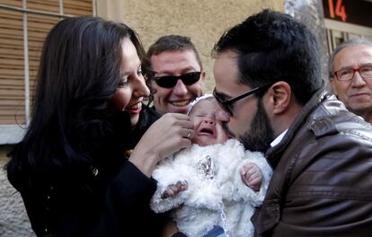 Una pareja celebra su buena suerte junto a su hija en la localidad madrileña de Leganés.