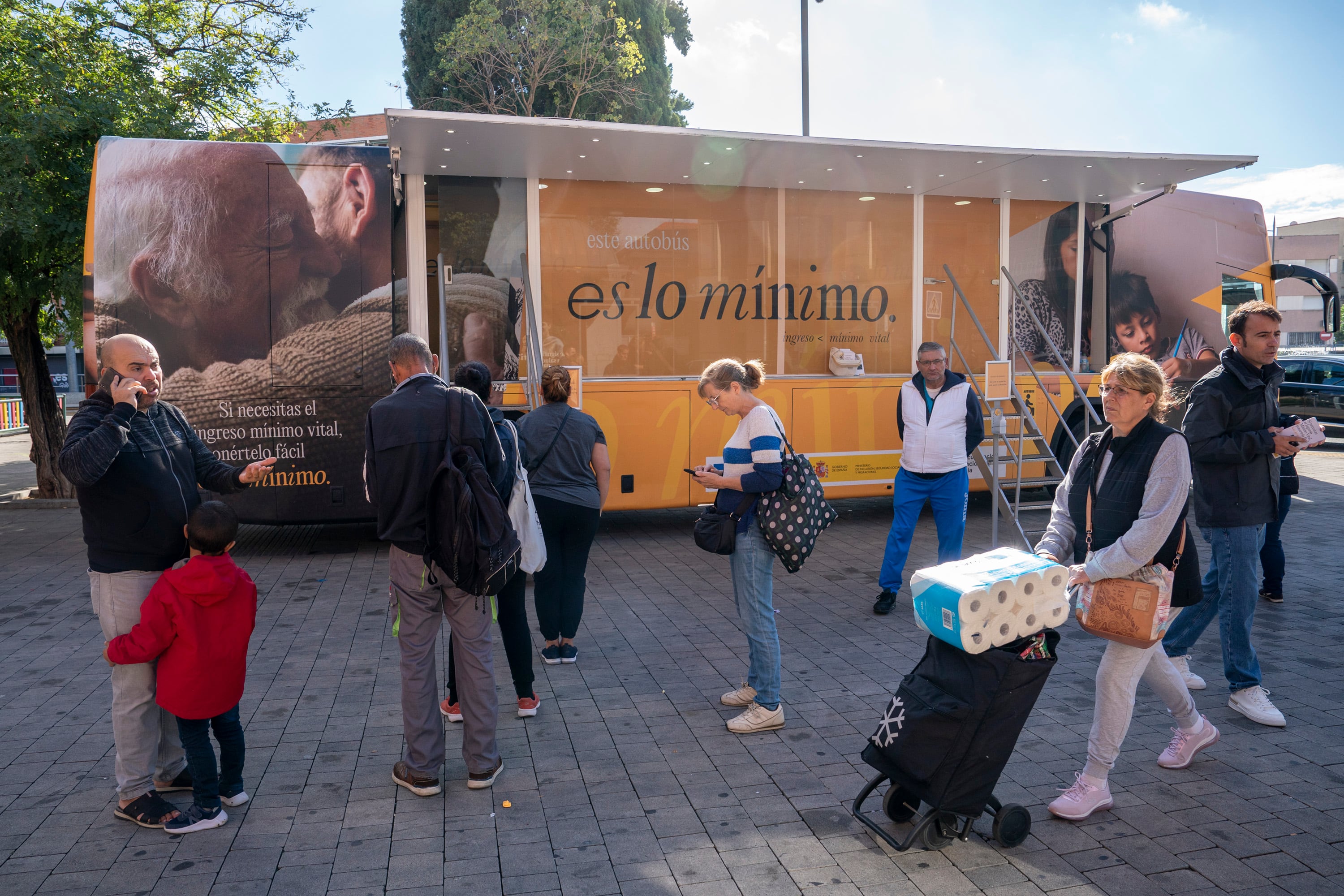 Varias personas ante un autobús informativo del IMV, en Parla (Madrid) en octubre de 2022.