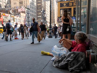 A homeless woman rests on a Manhattan street during a heat wave on July 22, 2022.