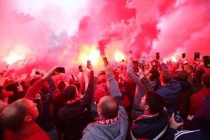 Aficionados de los 'reds' encienden bengalas a las afueras del estadio Anfield, en Liverpool, antes del inicio del partido.