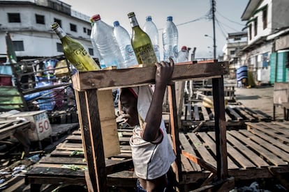 Un niño lleva botellas vacías en una calle de Brazzaville (República del Congo).