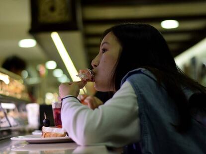 Una noia menjant-se un pintxo a la Maitea Taberna.