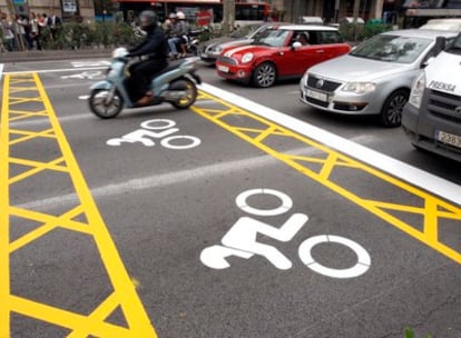 Un motorista se coloca por delante de los coches ante un semáforo en las zonas reservadas para ellos en Barcelona.