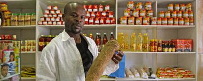 Sylvester Ekhosuehi muestra un tubérculo de ñame, uno de los productos tropicales que vende en su tienda de Fuenlabrada (Madrid). Quedó en libertad tras ser uno de los últimos detenidos en la redada.