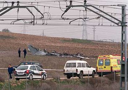 Efectivos de la policía inspeccionan ayer el descampado en el que cayó la avioneta siniestrada.