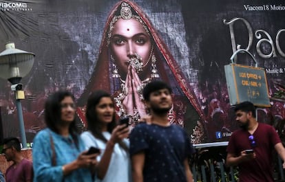 Varias personas pasan por delante de un cartel publicitario de la película 'Padmavati' en Bombay.