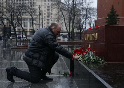 Un hombre deposita flores en memoria de las víctimas del atentado terrorista que ha tenido lugar en el metro de San Petersburgo.