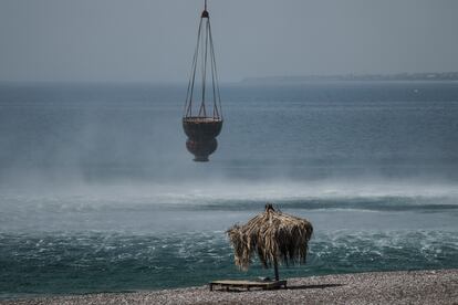 A helicopter fills water from the sea during a wildfire, near Gennadi village, on the Aegean Sea island of Rhodes