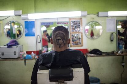 Un seguidor de la selección brasileña de fútbol elige el retrato de Neymar como diseño de su corte de pelo en Río de Janeiro.