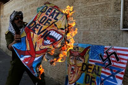 Un palestino quema un dibujo que representa a Donald Trump durante una protesta contra el plan de Bahréin de paz con los Estados Unidos, en la ciudad de Gaza.