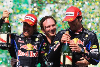 Red Bull drivers Sebastian Vettel (l) ad Mark Webber (r) along with team boss Christian Horner on the podium at Interlagos