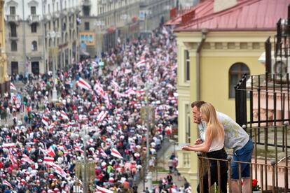 Una pareja observa desde un balcón la multitudinaria manifestación, en Minsk. 