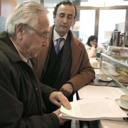 El abogado de Trashorras, Gerardo Turiel, a la izquierda, lee el fallo en una cafetería.