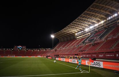 El capitán del FC Barcelona Lionel Messi saca un corner con las gradas del estadio del Mallorca sin público. 