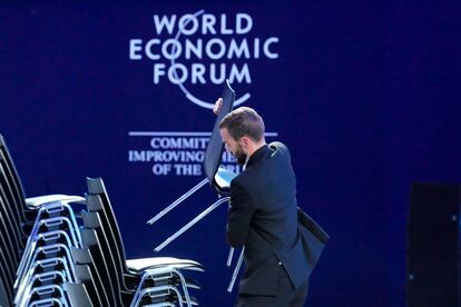 Un asistente coloca sillas tras una sesión en el Foro de Davos.