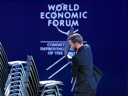 Un asistente coloca sillas tras una sesión en el Foro de Davos.