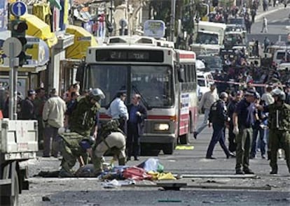 La policía israelí examina el cadáver del terrorista, tendido en el suelo con una sábana.