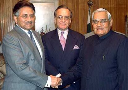 Musharraf y Vajpayee se saludan ante la mirada del ministro paquistaní de Exteriores, Khursheed Mahmood Kasuri.