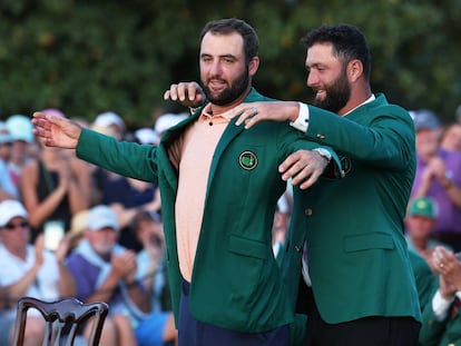 Jon Rahm pone la chaqueta de campeón a Scheffler.