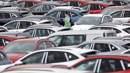 Una trabajadora de Ford camina entre automóviles aparcados en el exterior de la planta en Almussafes (Valencia).