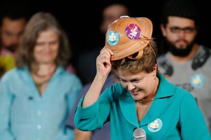 Dilma pega um chapéu de couro durante  ato em Brasília, no dia 13.