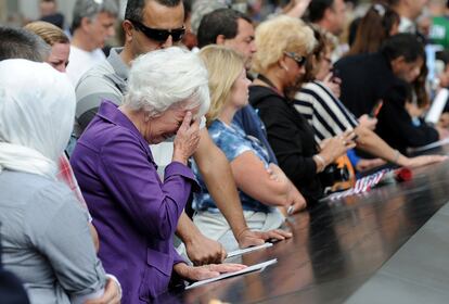 Una mujer llora frente a los paneles de bronce con los nombres de la víctimas del 11-S, en la 'zona cero' de Nueva York.