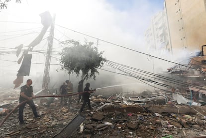 Varios trabajadores apagan un incendio en un edificio bombardeado en los suburbios del sur de Beirut, Líbano, este domingo.