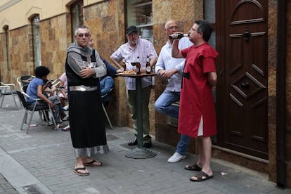 Unos hombres disfrazados con trajes medievales toman cervezas durante la celebración de feria medieval en Mansilla de las Mulas.