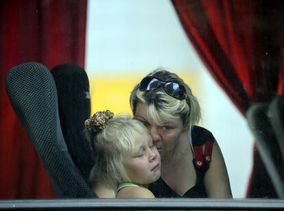 Una niña llora junto a su madre dentro del autobus que las llevará a Rusia en Donetsk (Ucrania).