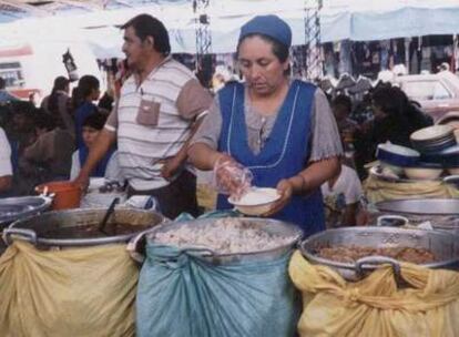 Una boliviana en su puesto, abierto con microcrédito.