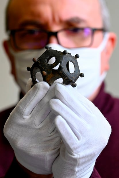 Un investigador francés sostiene en sus manos un dodecaedro romano hallado en Metz, al este de Francia, en diciembre de 2020.