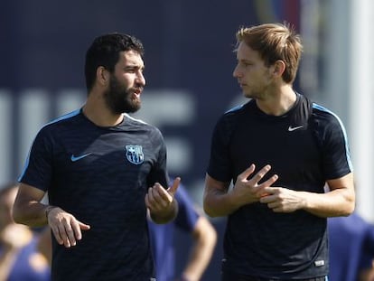 Arda Turan conversa con Rakitic en un entrenamiento del Barça.