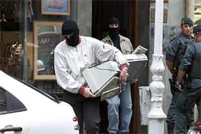 Guardias civiles se llevan un ordenador tras el registro, ayer, de un domicilio en San Sebastián.