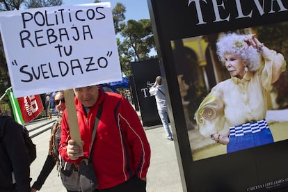 Un manifestante junto a un cartel publicitario con la imagen de la Duquesa de Alba, en Sevilla.