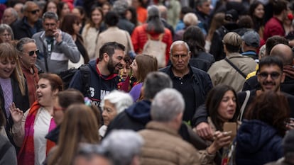 Dos personas se sonríen entre la multitud viandantes, en la Rambla de Barcelona, este martes durante el día de Sant Jordi.