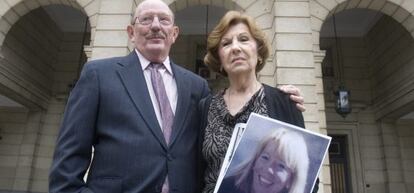 Los padres de Laura Cerna, con una foto de su hija en la puerta de los juzgados de Sevilla.