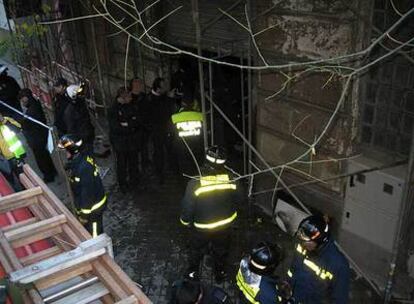 Varios bomberos, en la puerta del edificio donde se ha registrado el siniestro.