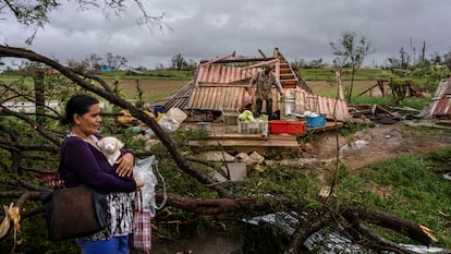 Mercedes Valdez sujeta a su perra Kira mientras esperan el autobús tras perder su vivienda por el huracán en la localidad de Pinar del Río, este martes.